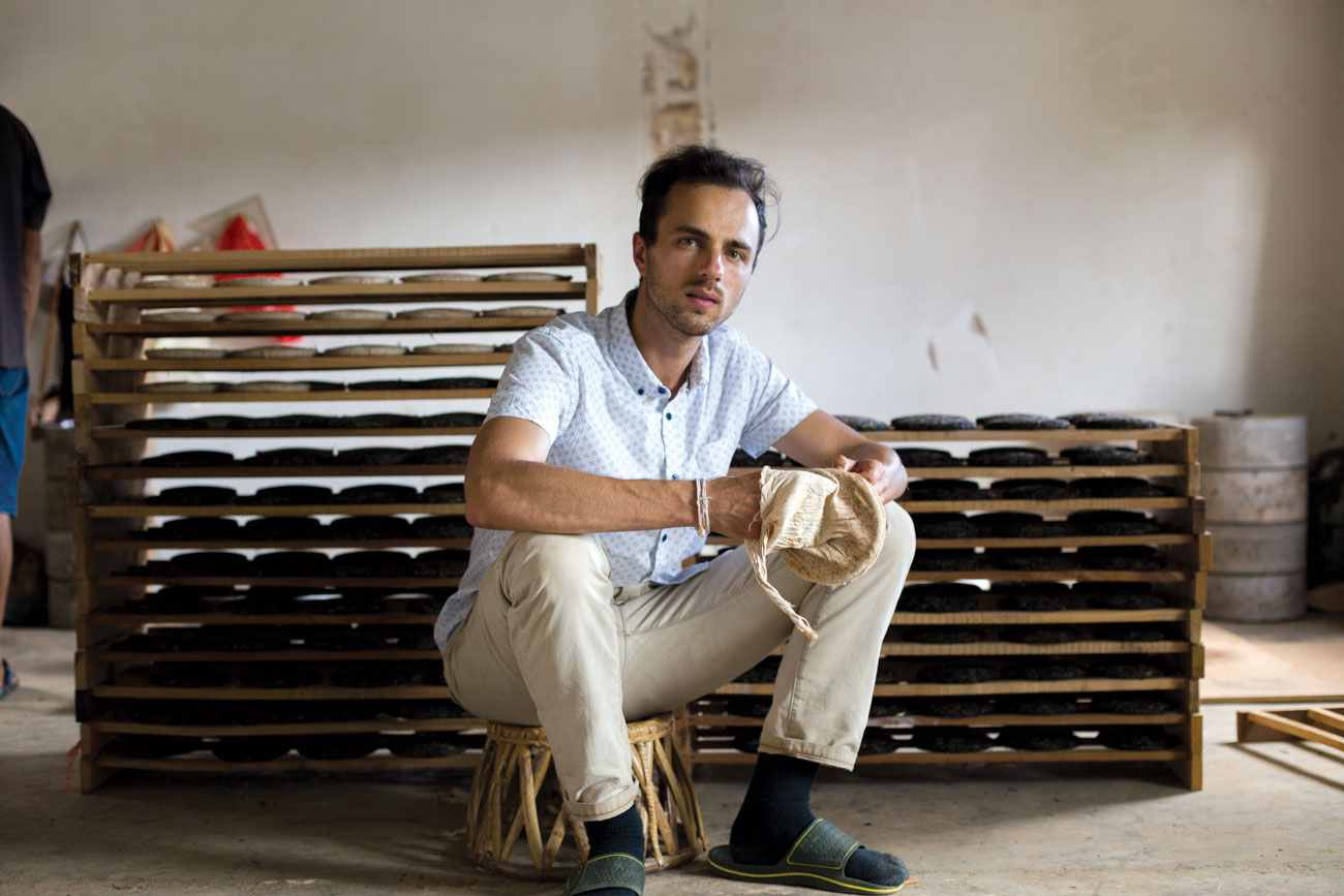 Nicholas Lozito holds a bag in which processed tea leaves are placed and then pressed into bings.