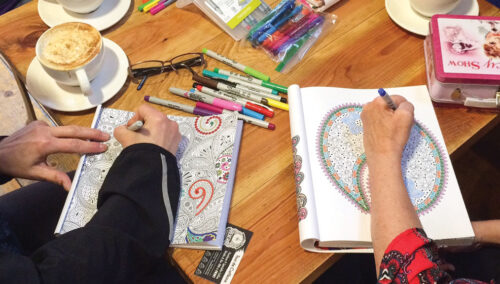adults coloring at Reverie Coffee Roasters; coloring in the café